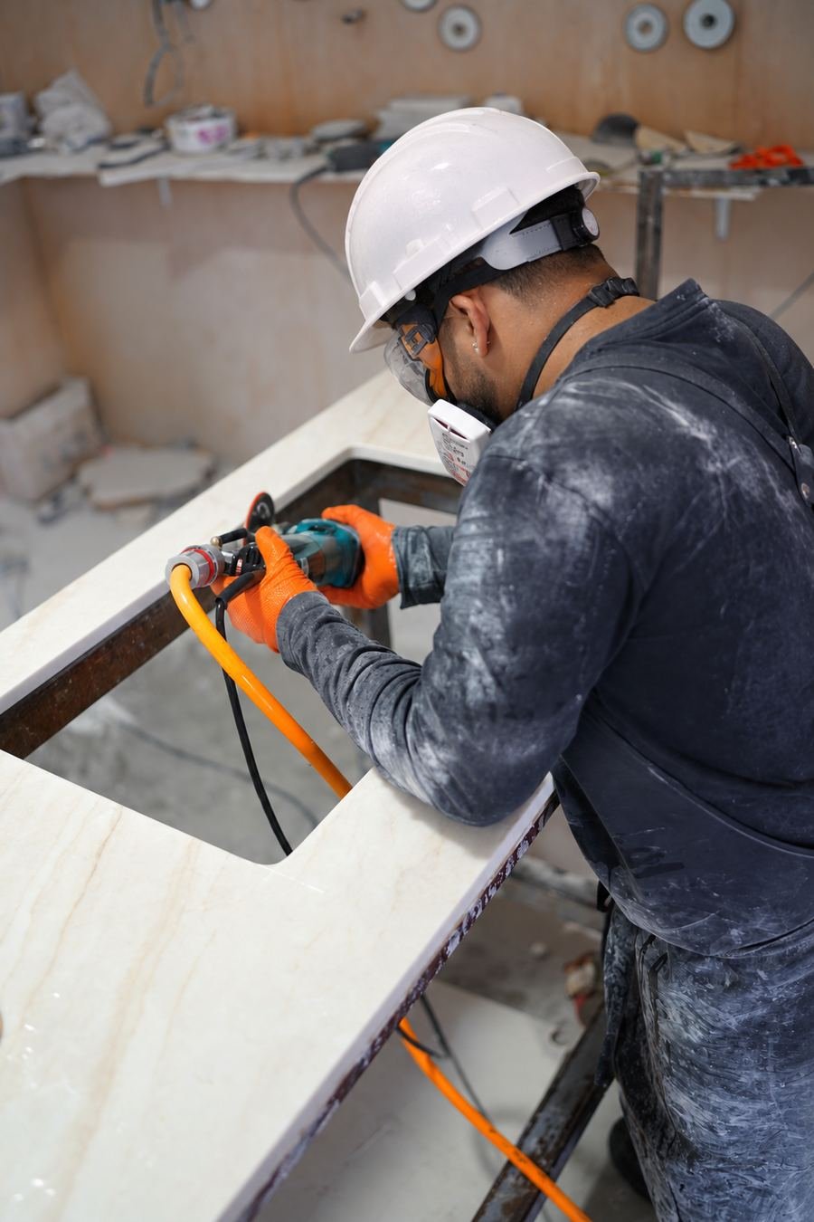 Fabricator polishing a stone edge